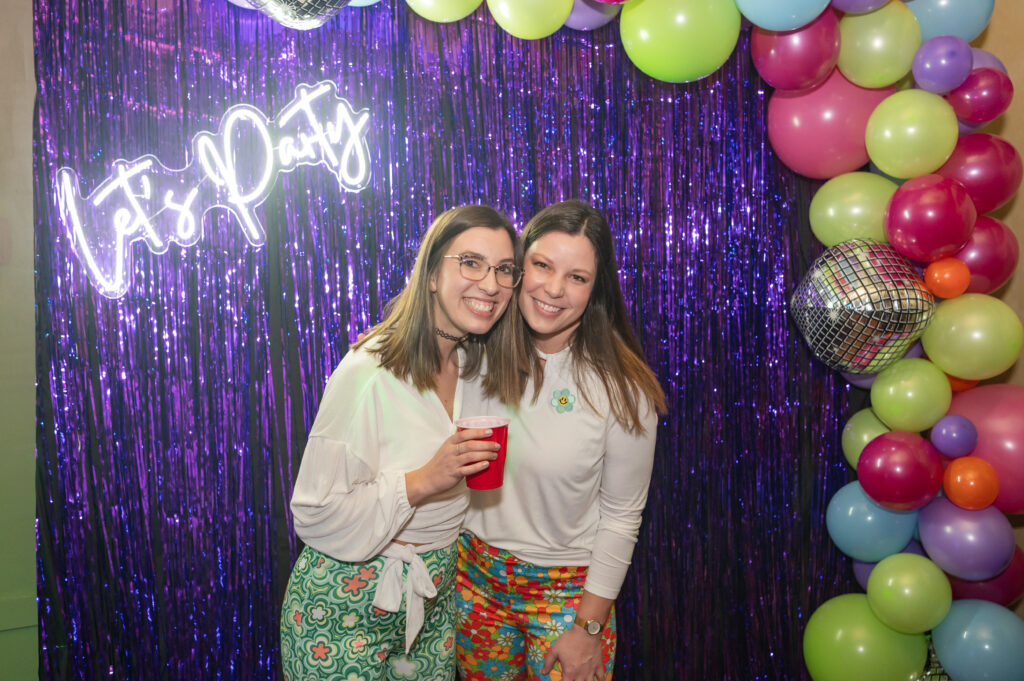 Disco themed backdrop with Let's Party sign and colorful balloon garland