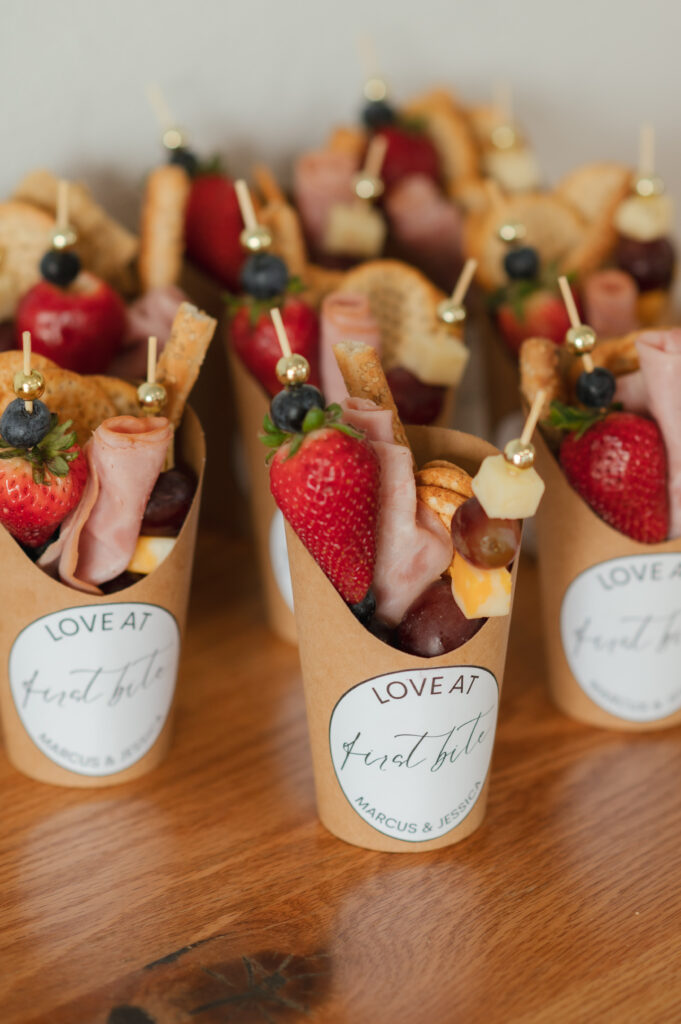 Charcuterie cups that read 'love at first bite' 'Marcus and Jessica'