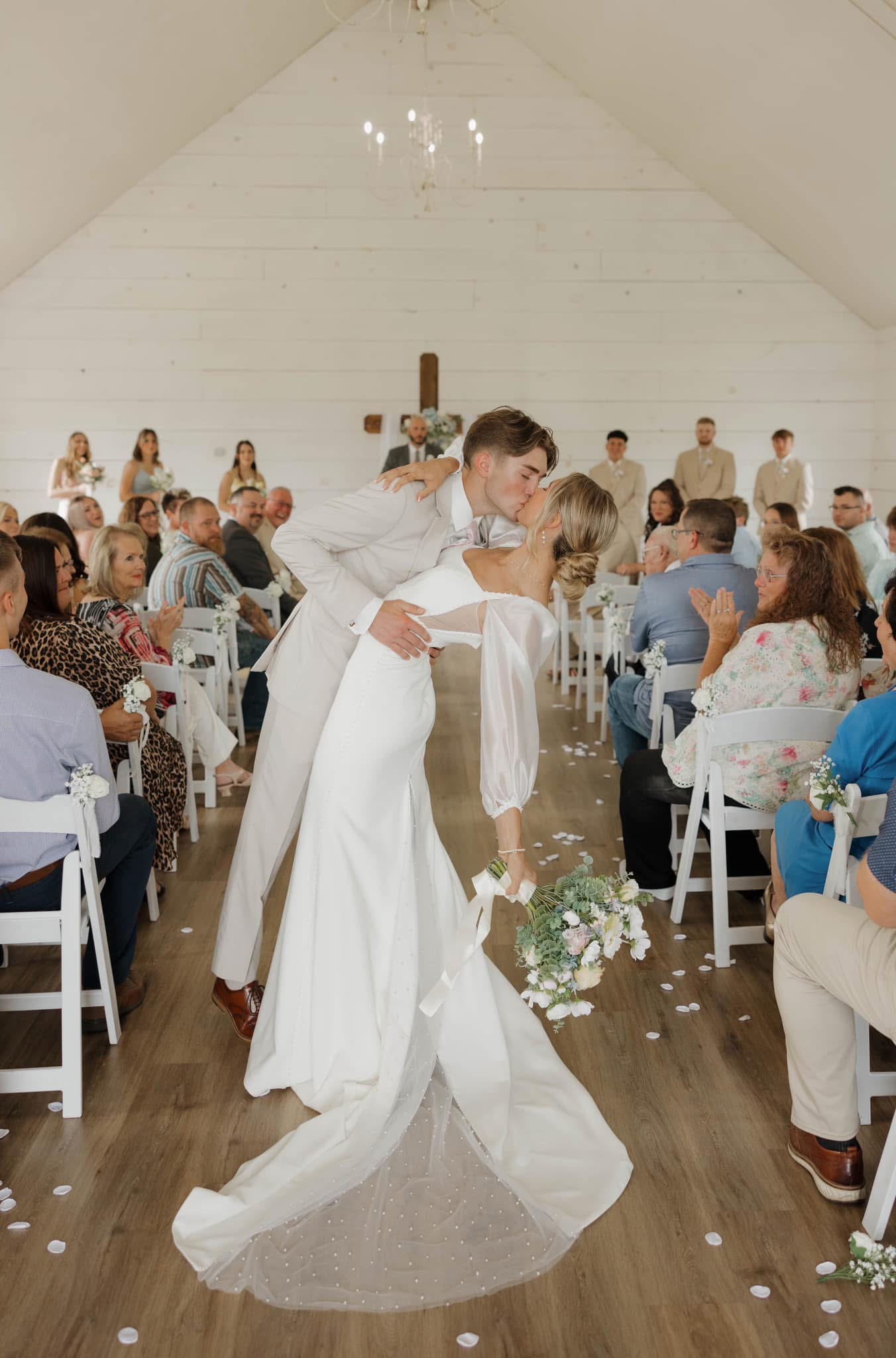 Bride and groom kissing at the end of their wedding aisle