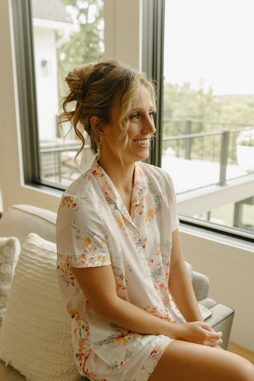 A bridesmaid smiling after having her wedding makeup done