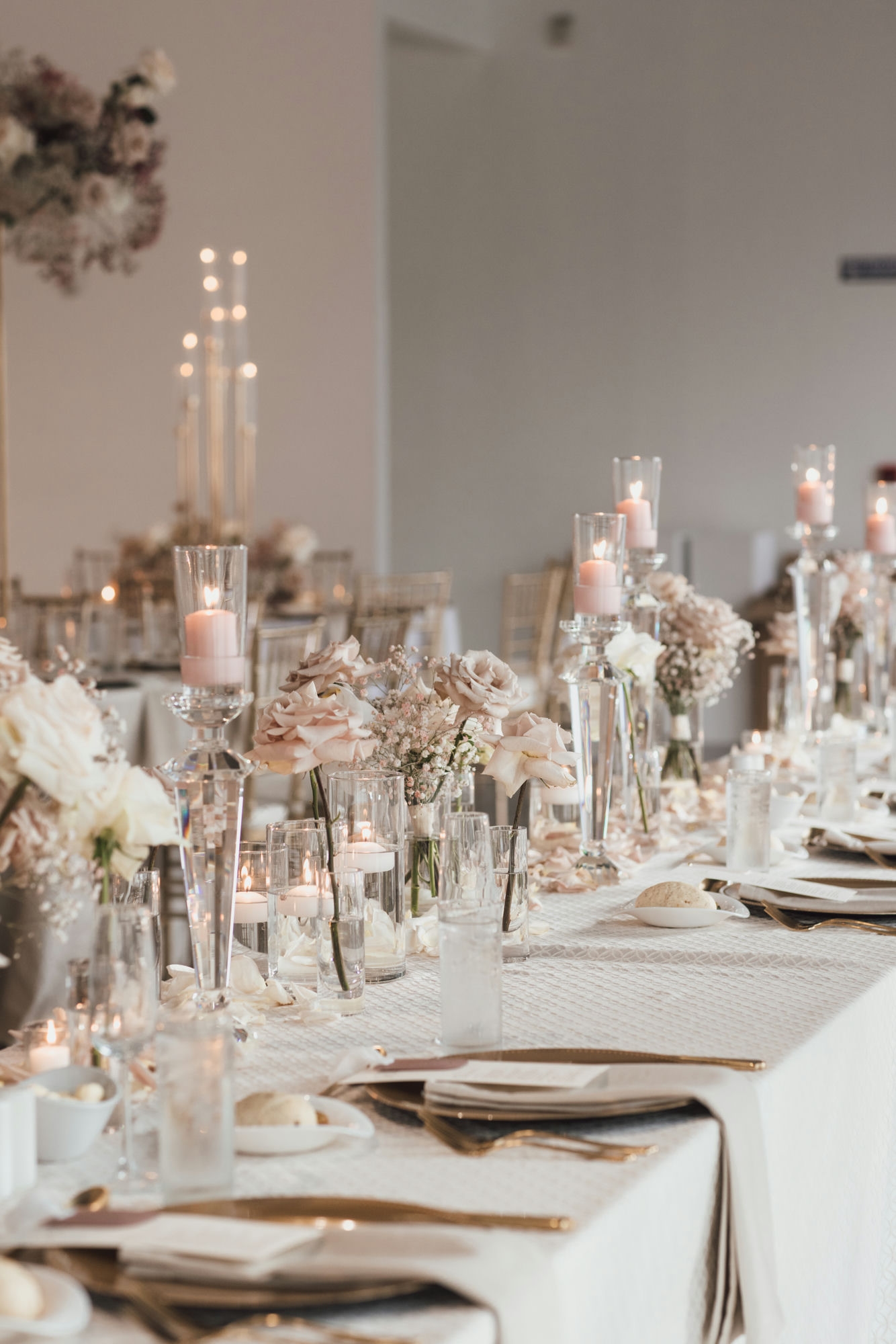 Elegant Iowa wedding reception tablescape with blush roses, tall candles, and gold accents planned by Legacy Events Iowa