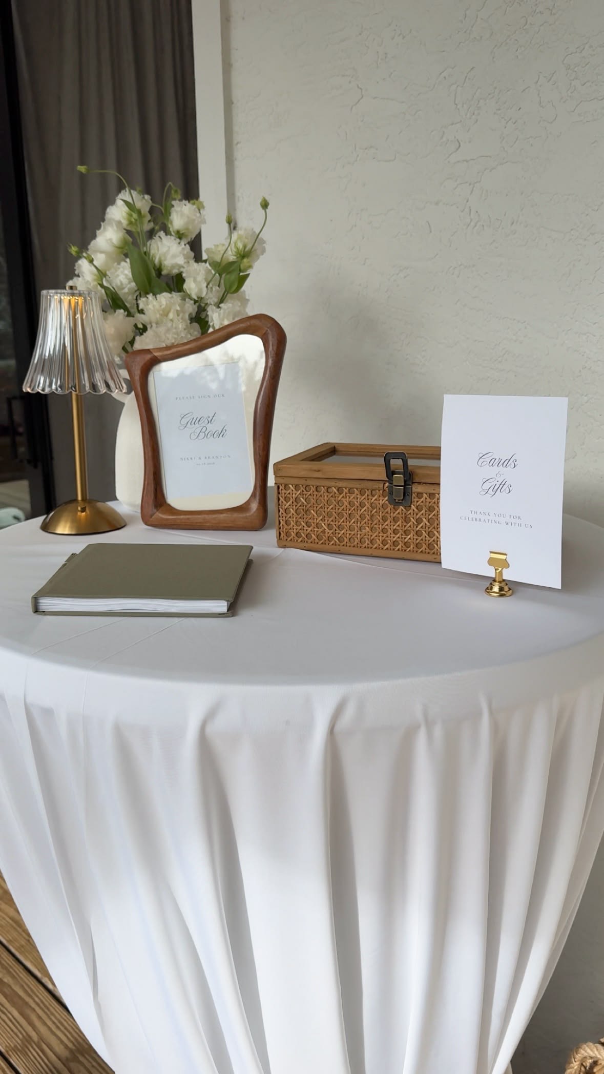 Wedding guest book and cards and gifts table with floral arrangement