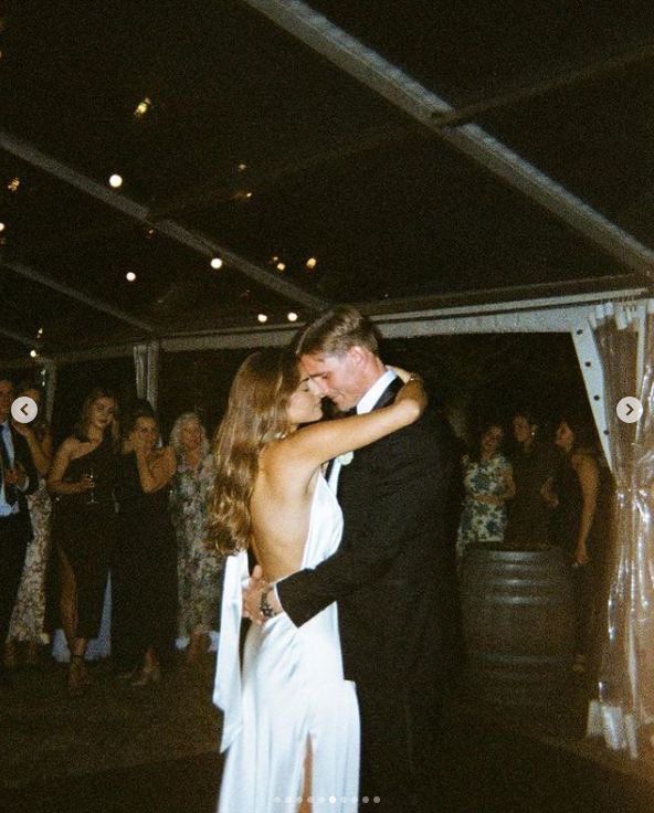 Bride and groom first dance under string lights at Iowa wedding reception