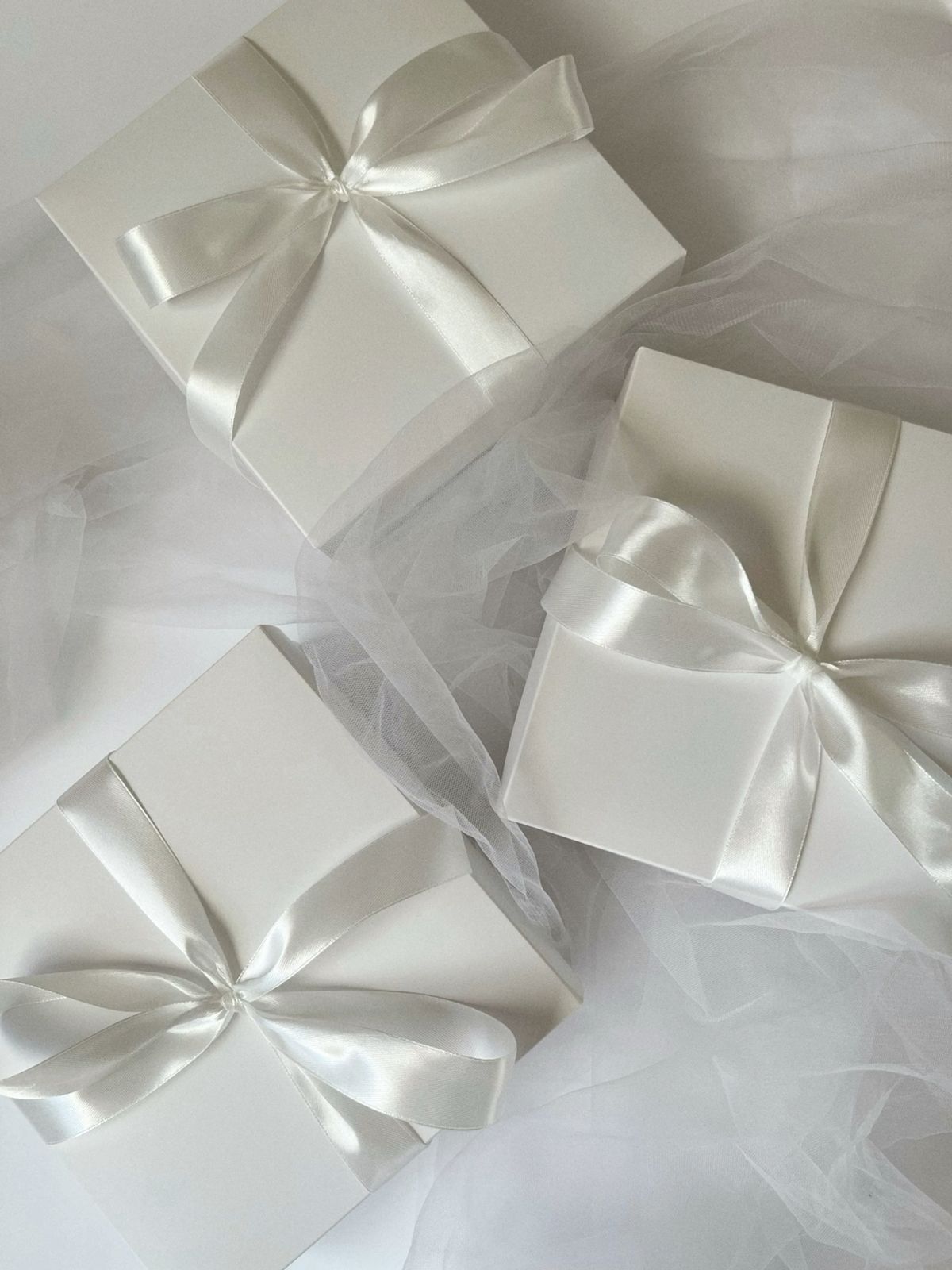 White wrapped wedding registry gift boxes with satin ribbon