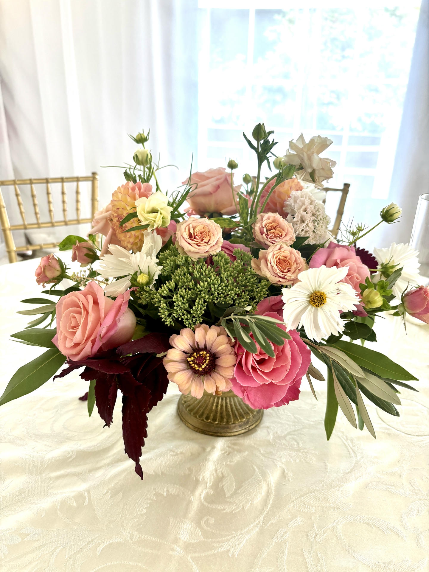 Wedding centerpiece with blush pink and white florals in a gold vase