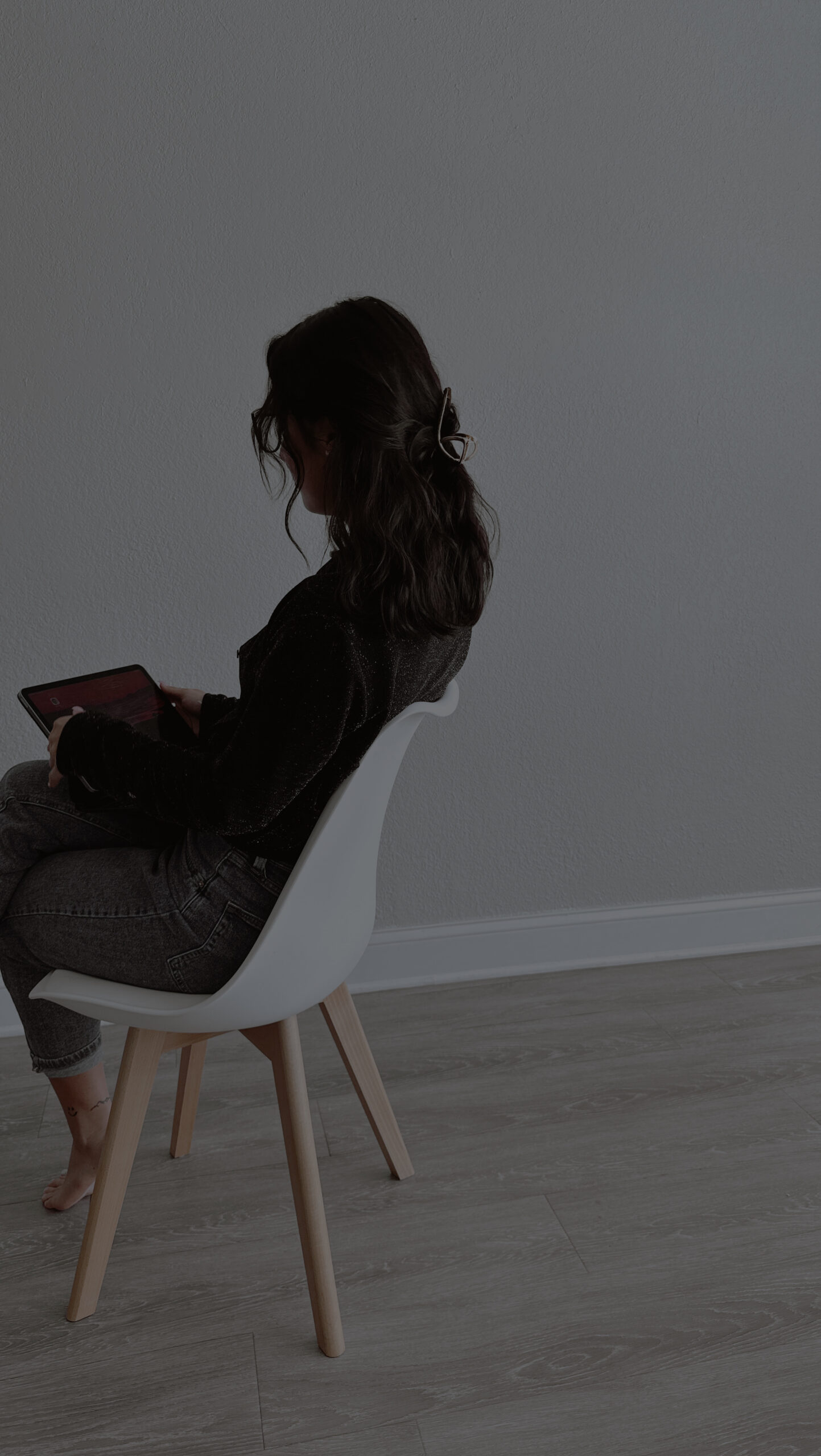 Wedding planner sitting in a chair reviewing plans on a tablet